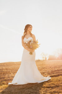 Bride holding bouquet during sunset