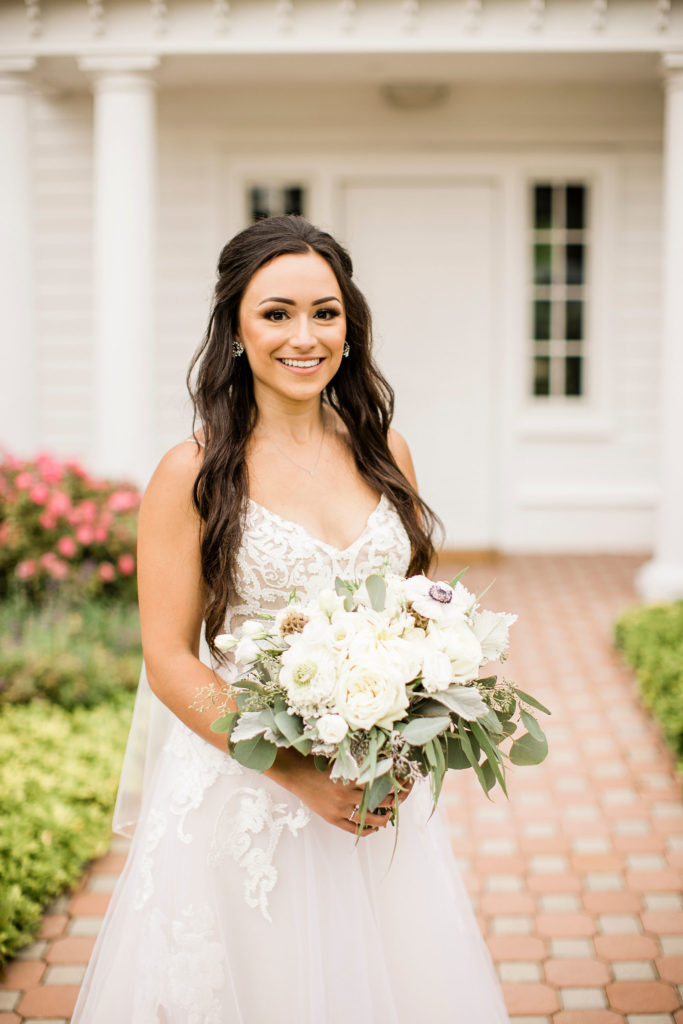summer bride holding her bouquet in front of the Ryland Inn